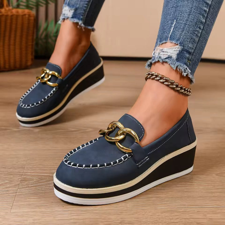 Scarpe slip-on donna con plateau robusto e catena dorata, perfette per stile primavera-autunno.