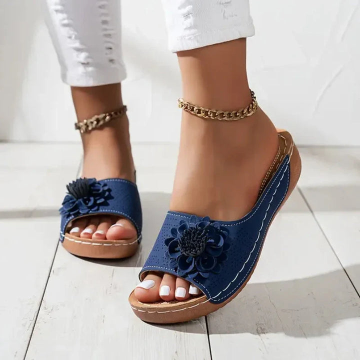 Massima comodità con queste ciabatte donna con zeppa, fiore decorativo e supporto plantare.