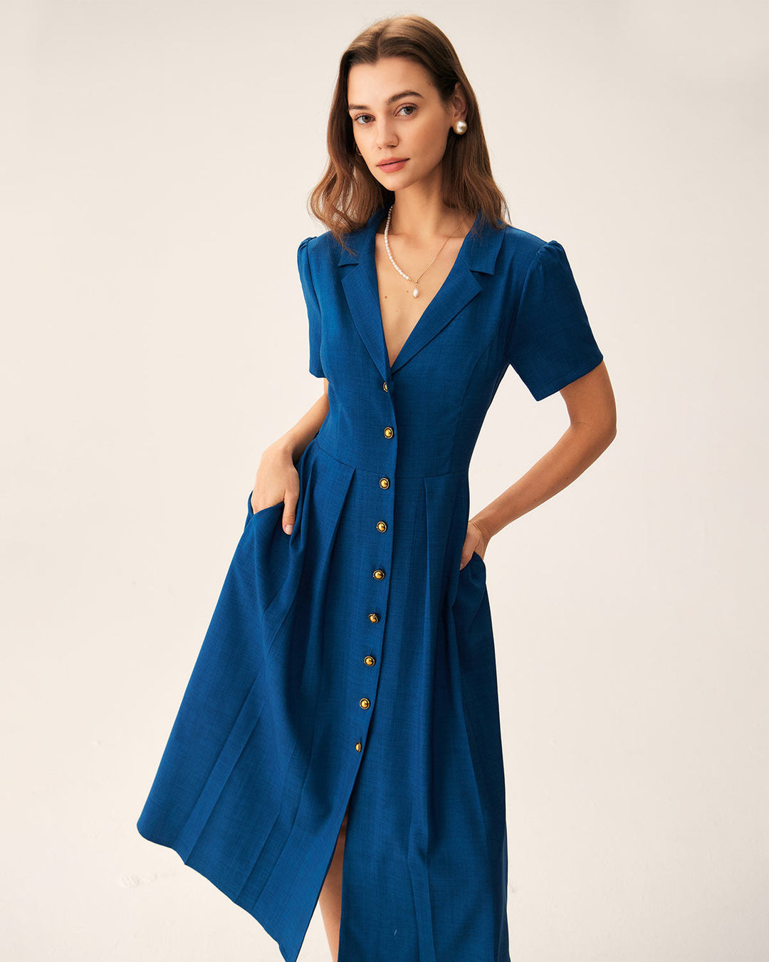 Abito da donna plissettato, blu, lunghezza midi, con scollo a V e bottoni; stile versatile e comodo.