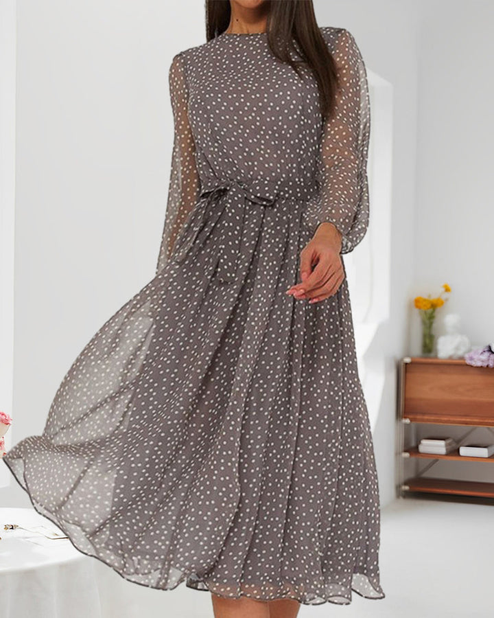 Abito da donna a pois grigio, linea A, con maniche lunghe. Un capo elegante e versatile per outfit ufficio.