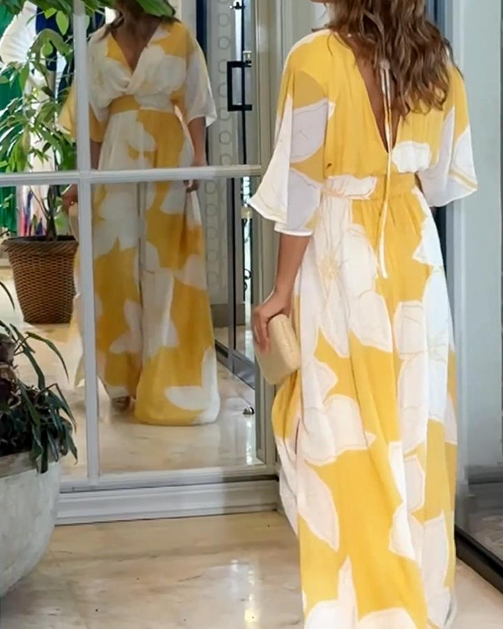Dettaglio abito midi donna giallo con stampa floreale, scollo a V e gonna ampia. Vestito estivo elegante e versatile.