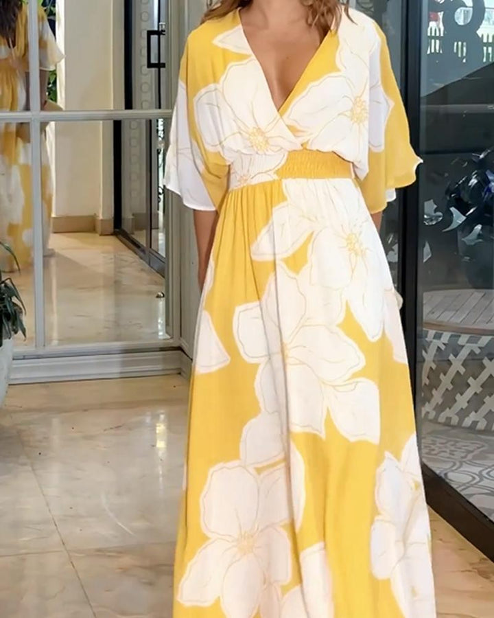 Donna indossa abito midi giallo a fiori con scollo a V, ideale per look estivi eleganti. Abbigliamento fluido e chic.