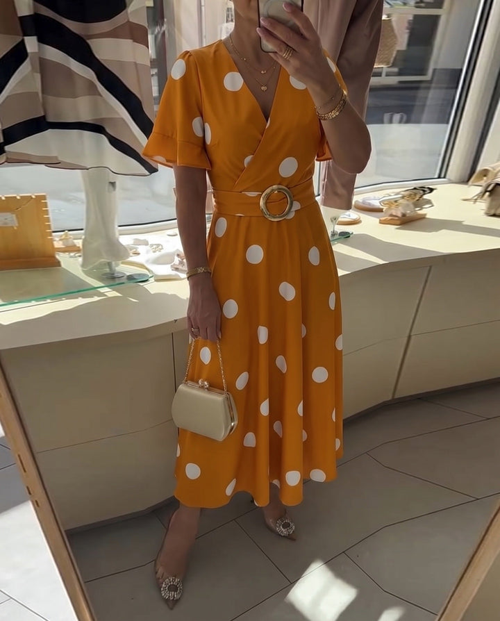 Abito midi a pois per donna, scollo a V. Femminile e versatile, perfetto per eventi o outfit quotidiani.