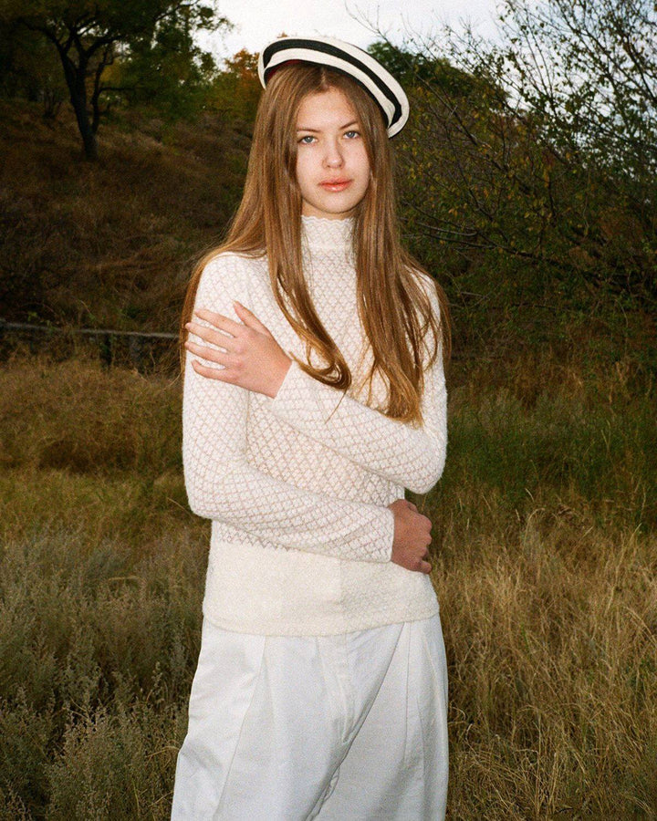 Maglia donna a collo alto trasparente, con dettagli in pizzo sulle maniche lunghe, casual chic.