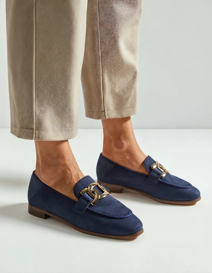 Mocassini donna opachi neri con fibbia dorata abbinati a outfit smart casual. Scarpe basse eleganti e comode.