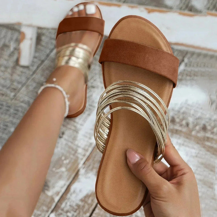 Sandali sliders ammortizzati con elegante doppia fascia e raffinato dettaglio metallico. Ideali per il comfort.