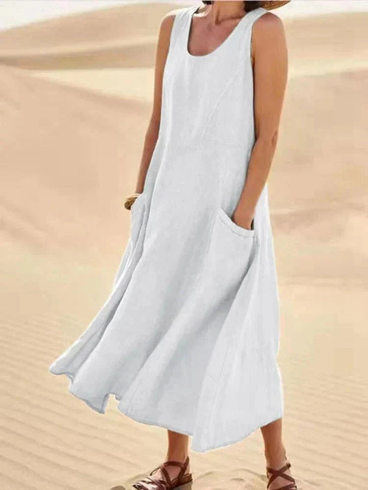 Abito lungo donna estivo con scollo rotondo e pratiche tasche laterali. Design senza maniche, fluido e casual.