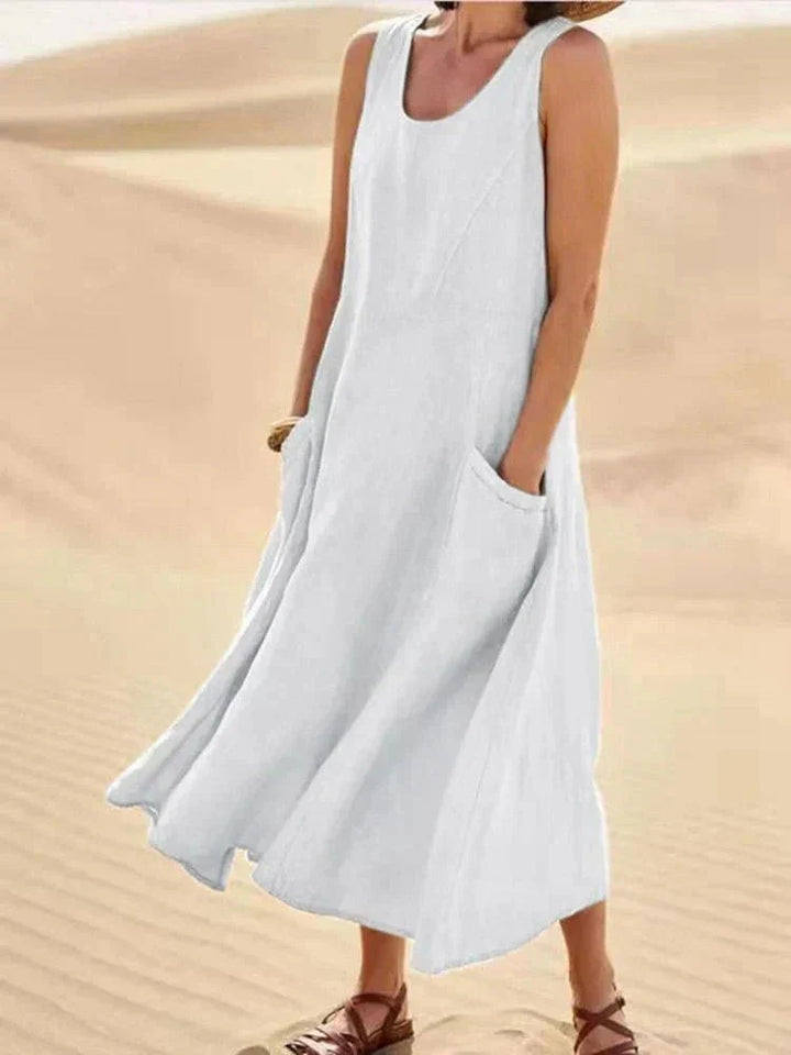 Abito lungo donna estivo con scollo rotondo e pratiche tasche laterali. Design senza maniche, fluido e casual.