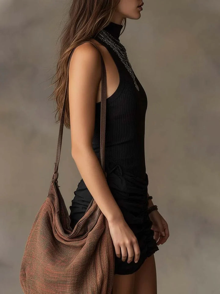 Abito da donna nero aderente per occasioni speciali, presenta un collo alto chic e una gonna drappeggiata.