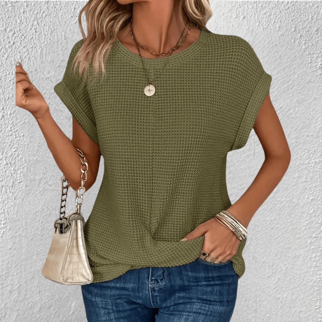 Dettaglio della trama distintiva sul top donna elegante. Girocollo, manica lunga, stile moda attuale.