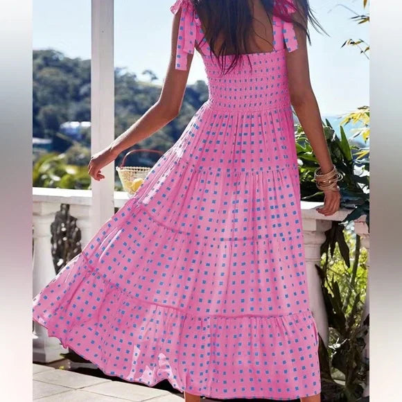 Abito midi rosa femminile, ideale per l'estate, con un raffinato top a nido d'ape. Eleganza e comfort per la donna.