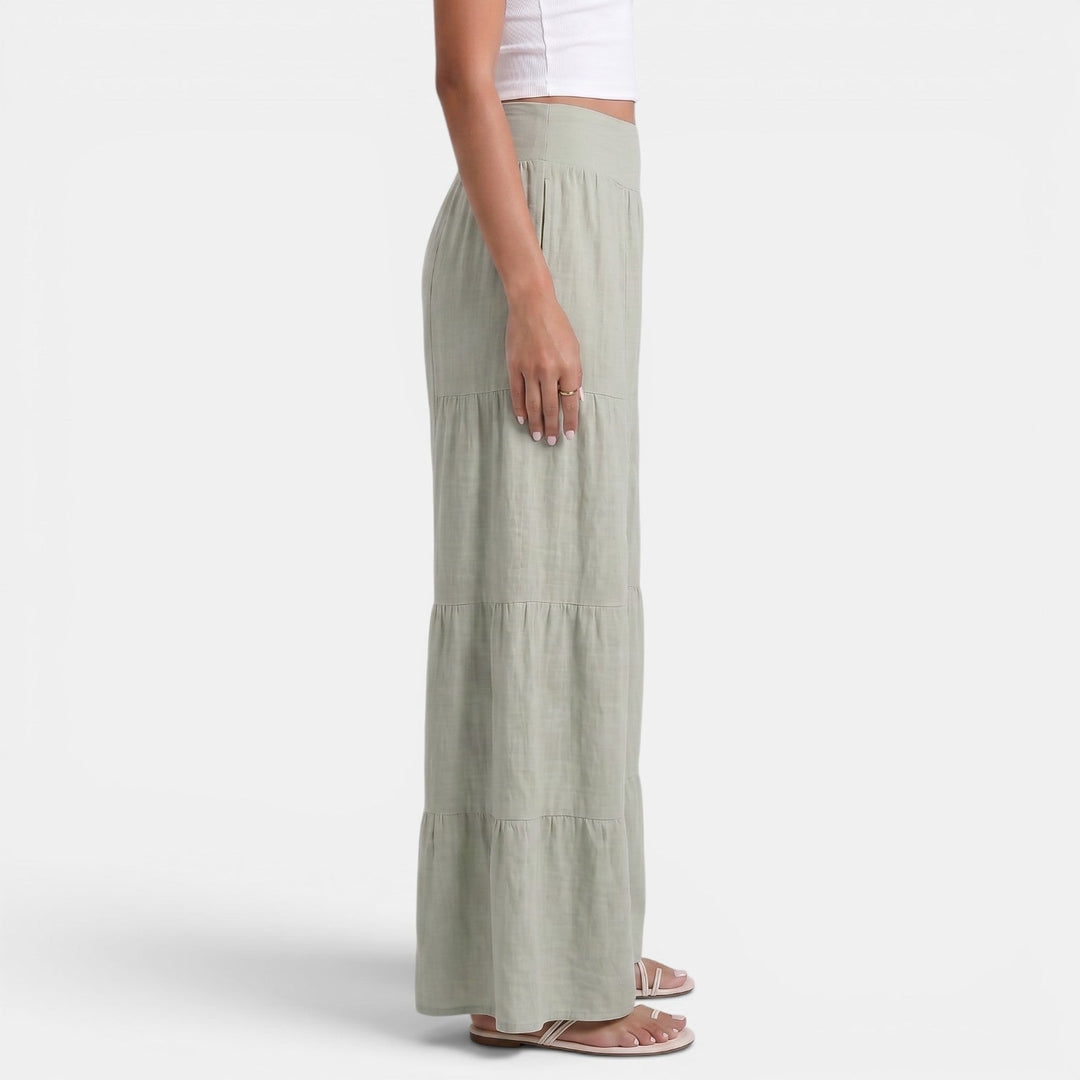 Modella indossa pantaloni donna ampi in lino bianco, leggeri e fluidi, perfetti per look estivi versatili.