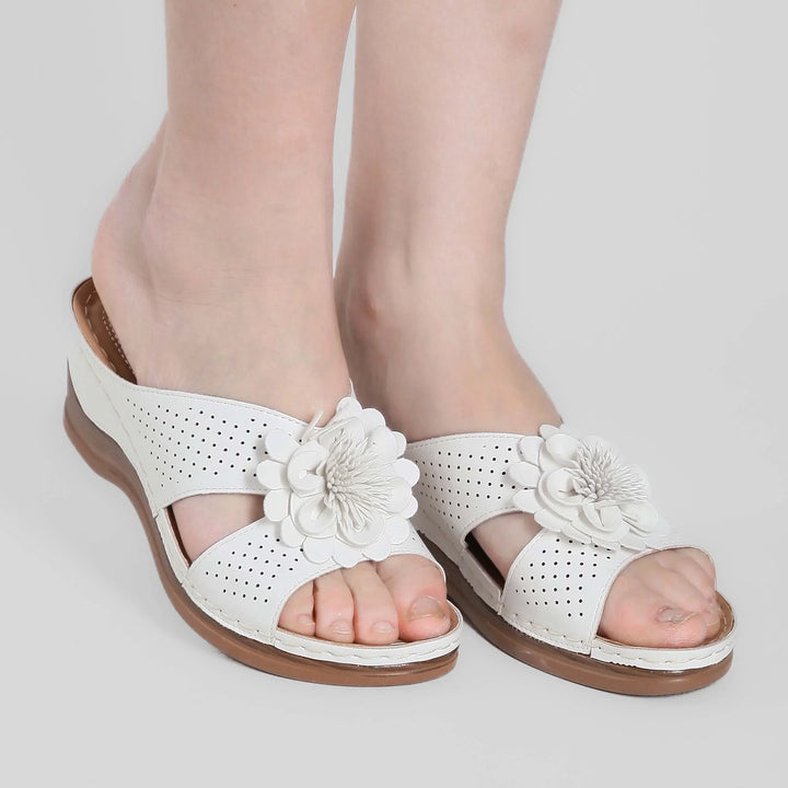 Sandali moda donna con zeppa, motivo floreale e fascette regolabili.