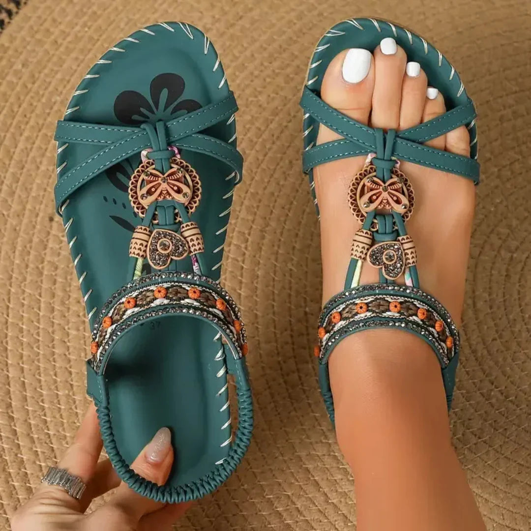 Sandali infradito da donna con dettagli di perline e vivace suola floreale, per un look estivo casual e alla moda.