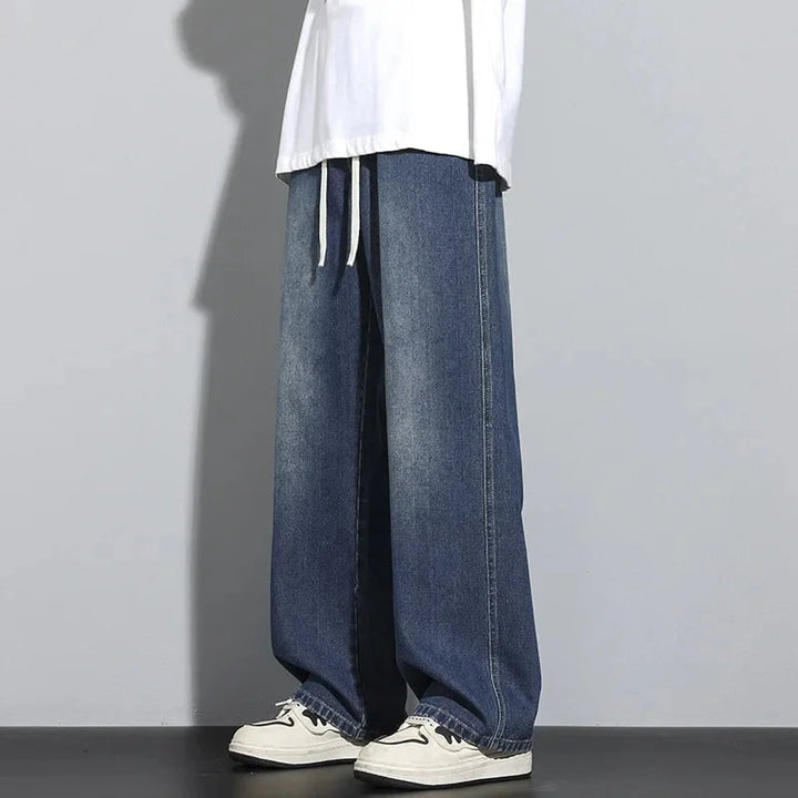 Uomo indossa jeans larghi dritti, vita regolabile, per un look casual-chic e streetwear. Perfetti per il tempo libero.