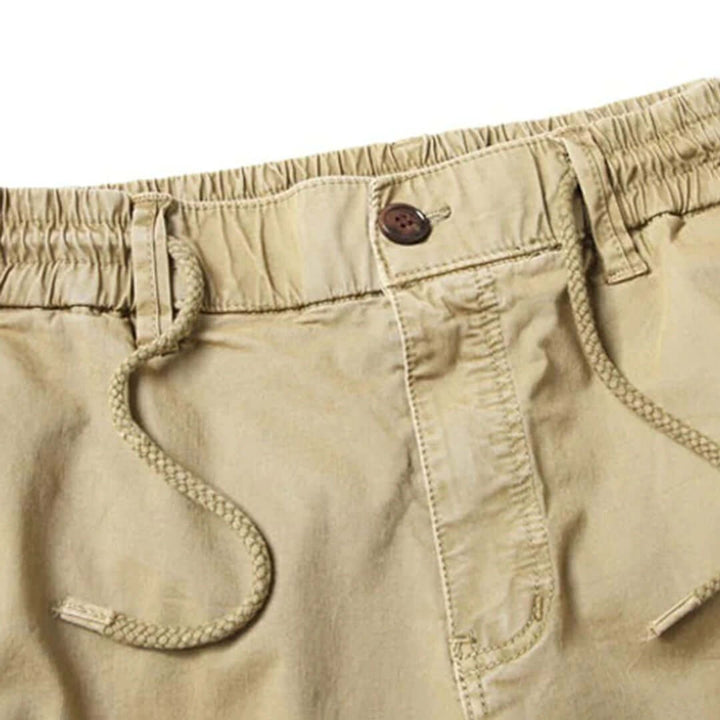 Modello casual di pantaloni cargo jogger uomo beige, design moderno e tasche multiple funzionali.