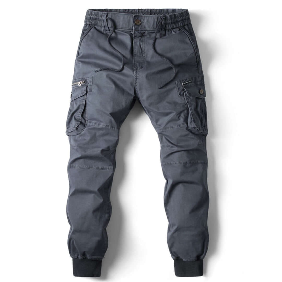 Dettaglio dei pantaloni cargo jogger grigi da uomo, con elastico alle caviglie e tasche laterali.