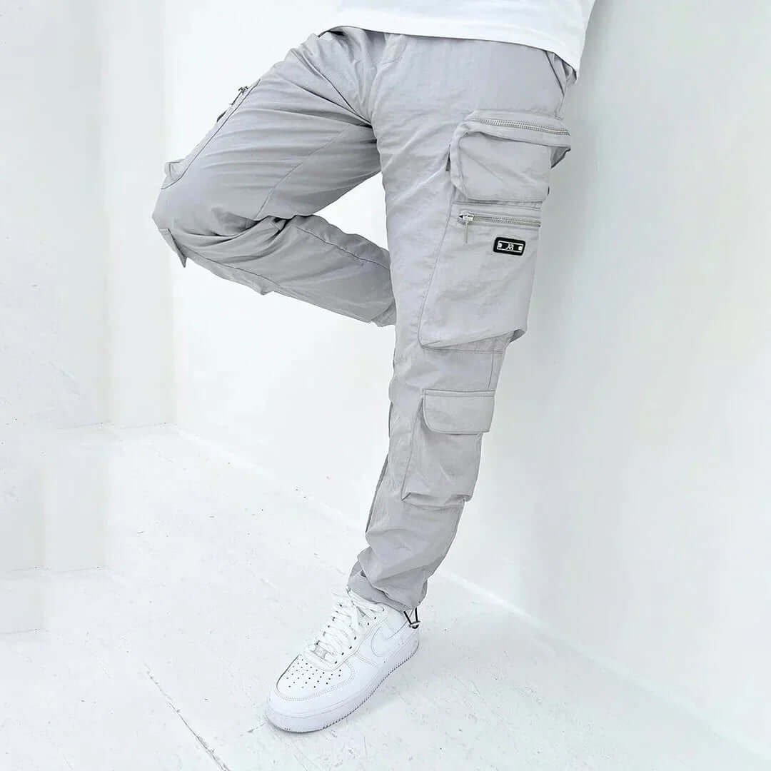 Pantaloni cargo uomo con design affusolato e ampie tasche laterali, perfetti per un look utility streetwear alla moda.