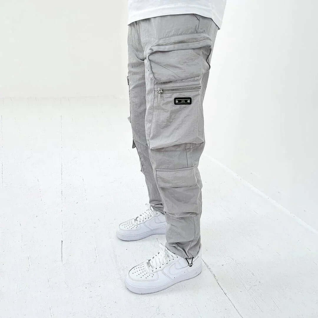 Pantaloni cargo uomo affusolati beige, che evidenziano il taglio moderno e le pratiche tasche per un uso quotidiano.