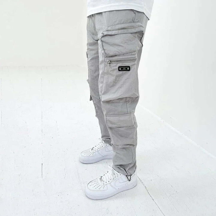 Pantaloni cargo uomo affusolati beige, che evidenziano il taglio moderno e le pratiche tasche per un uso quotidiano.
