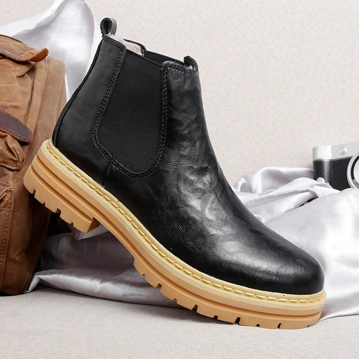 Stivaletti Chelsea da uomo neri con platform e suola carrarmato. Scarpe slip-on moderne per stile e comfort quotidiano.