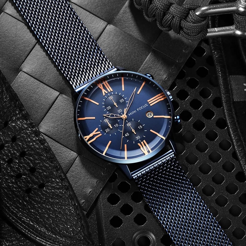 Dettaglio quadrante orologio cronografo uomo con numeri romani classici e contatori, cinturino in acciaio milanese.