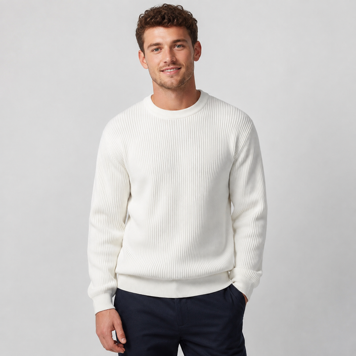 Uomo seduto, indossa un maglione girocollo comodo, vestibilità rilassata, ideale per serate invernali e comfort.