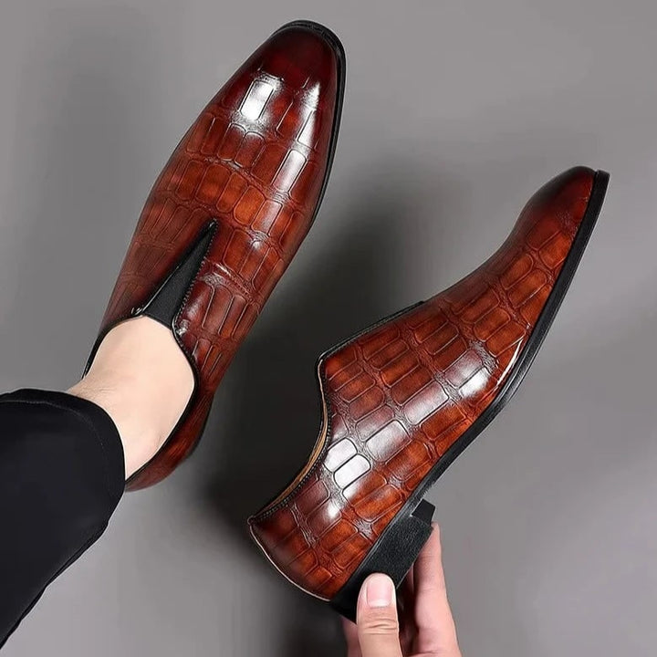 Dettaglio texture coccodrillo su mocassini uomo eleganti. Scarpe di lusso slip-on, perfette per cerimonie, colore nero.