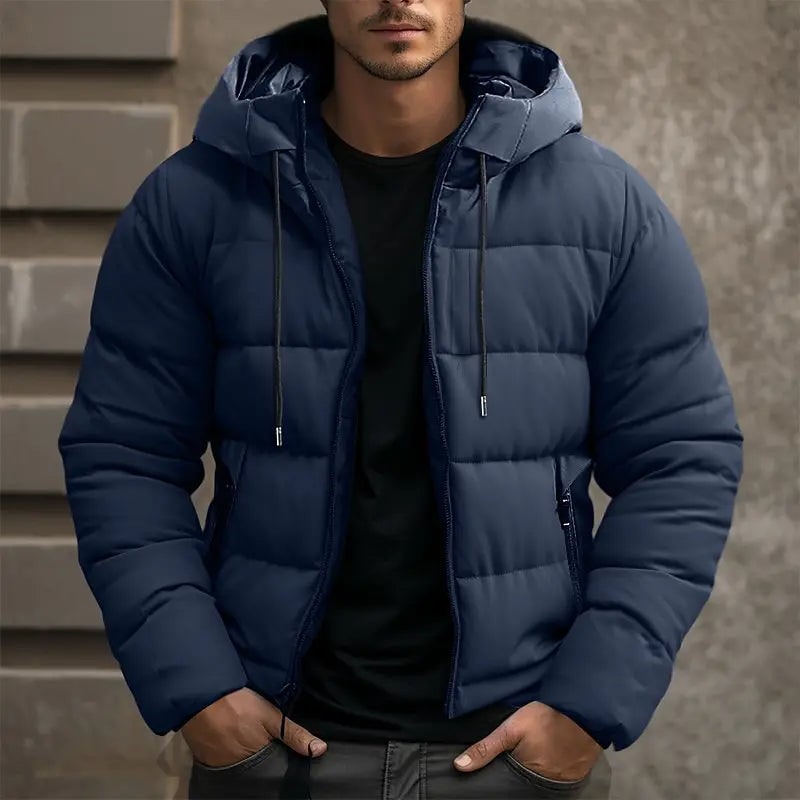 Giacca piumino uomo invernale con cappuccio e tasche zip, calda e trapuntata, disponibile in nero, grigio e blu.