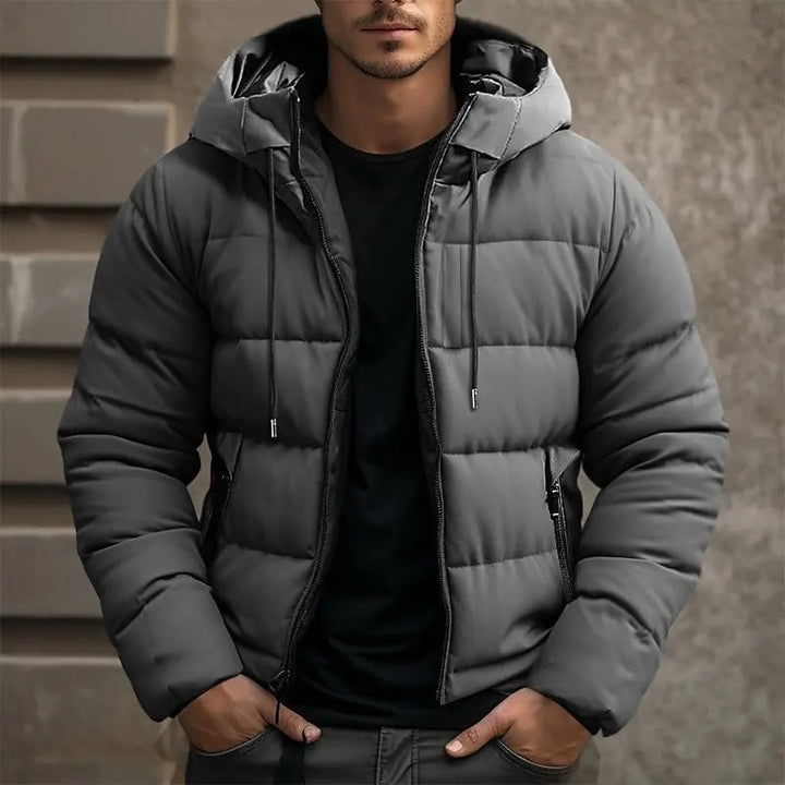 Giacca piumino uomo con cappuccio, tasche zip, calda e perfetta per l'inverno. Disponibile in nero, grigio e blu.