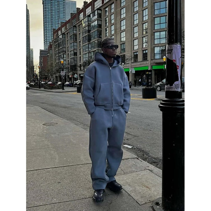 Felpa zip oversize da uomo abbinata a pantaloni ampi, ideale per un look athleisure comodo e alla moda.