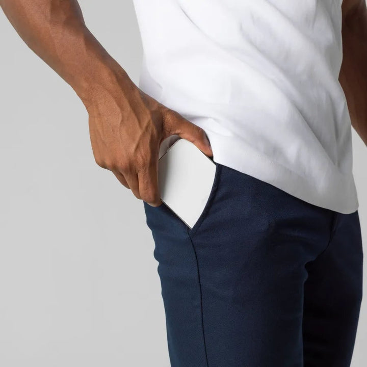 Uomo in piedi con pantaloni Chino grigi Slim Fit affusolati, stretch, look casual moderno.