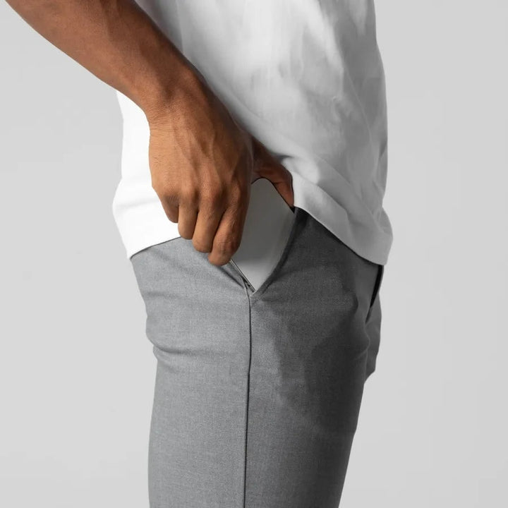 Uomo che indossa pantaloni Chino grigi Slim Fit affusolati con stretch, per outfit casual elegante.