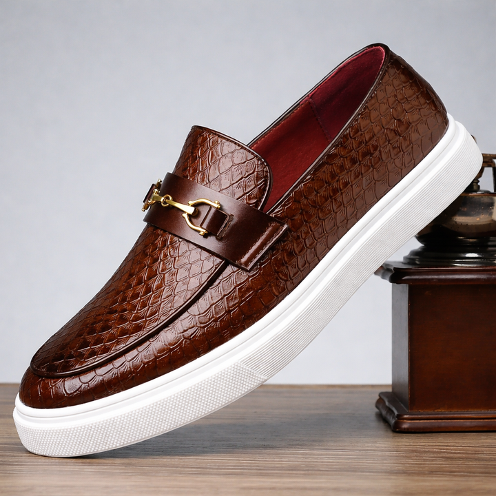 Mocassini uomo slip-on neri con morsetto dorato. Stile elegante e casual per comfort quotidiano.