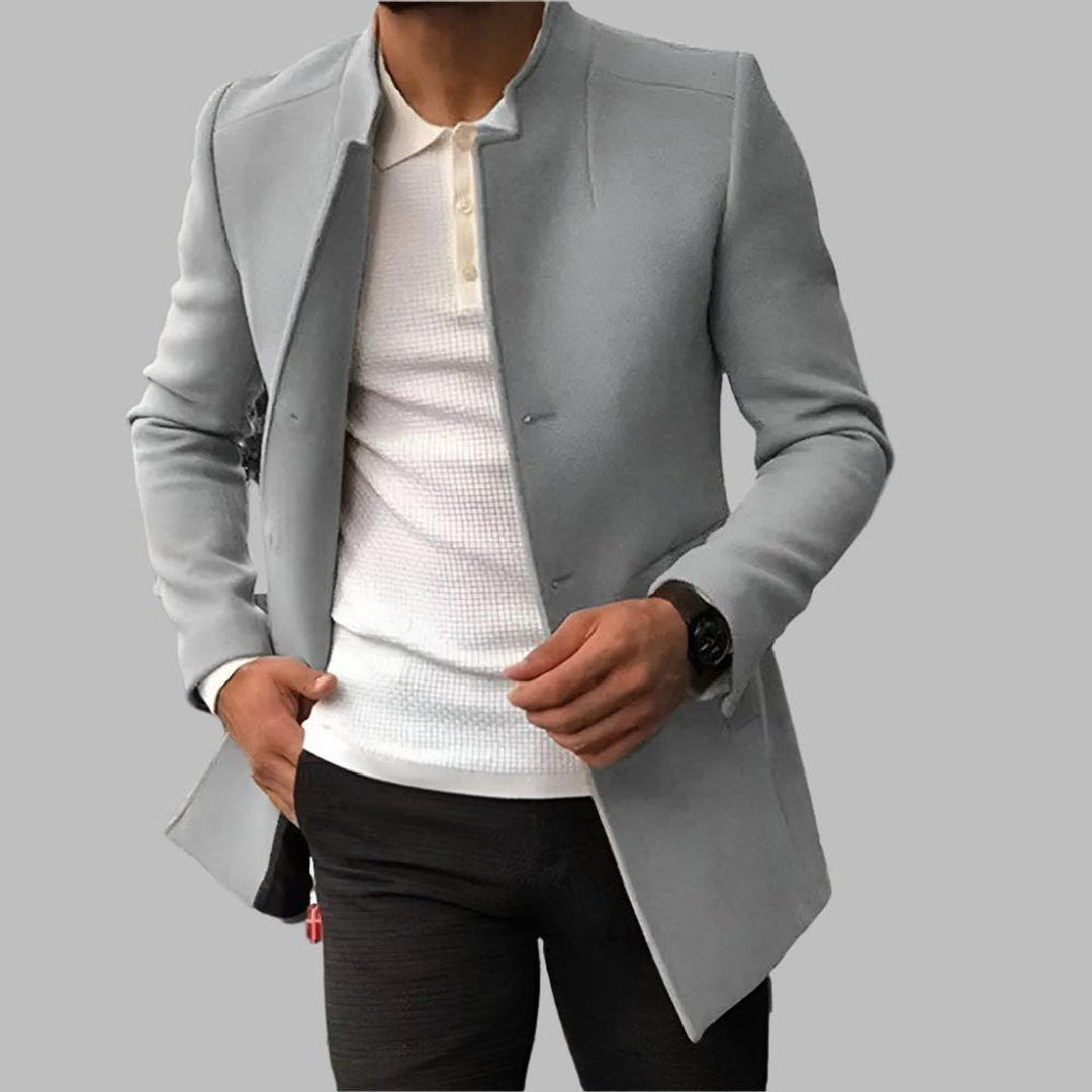 Uomo indossa cappotto slim fit con collo alla coreana e bottoni. Giacca moderna ed elegante per l'inverno.