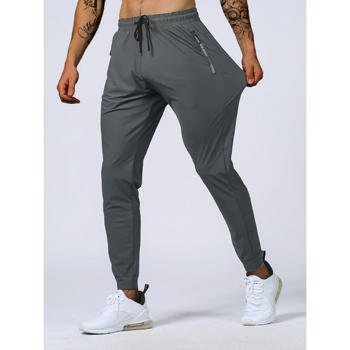 Joggers sportivi da uomo elasticizzati neri con tasche zip, ideali per athleisure, allenamento e comfort quotidiano.