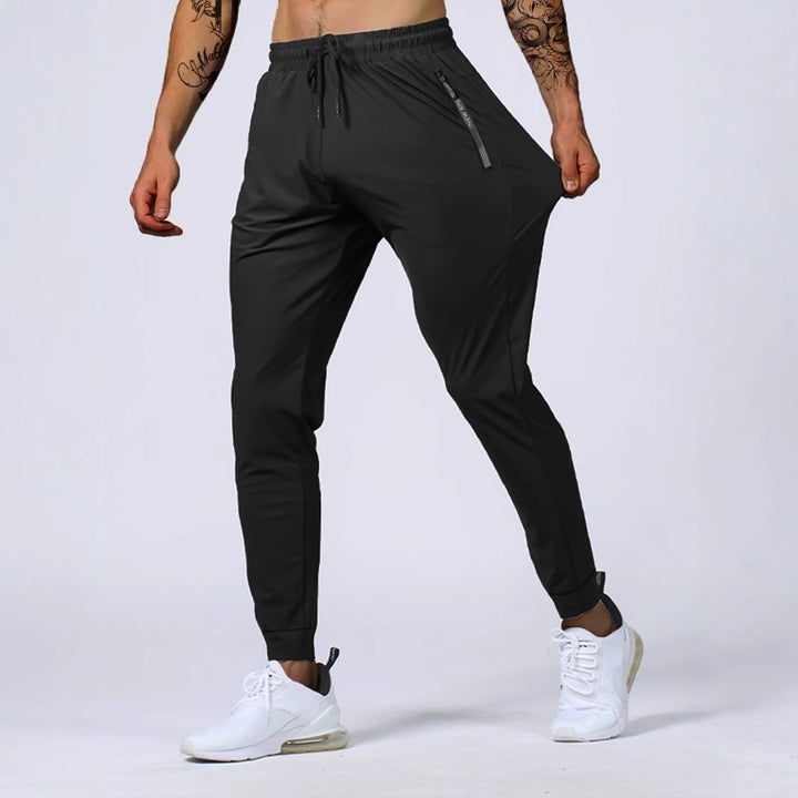 Joggers uomo elasticizzati verde militare con dettagli zip, ottimi per fitness, allenamento e stile athleisure.