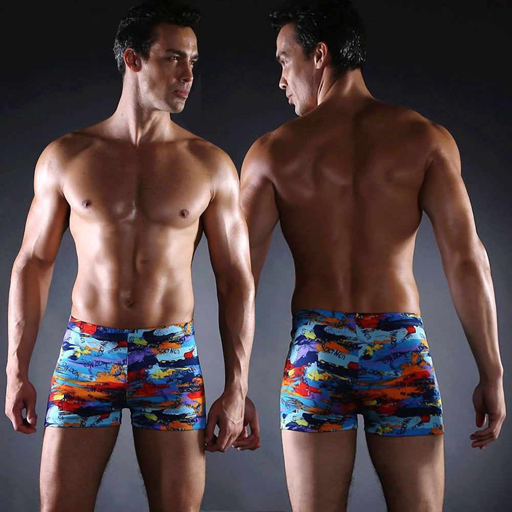 Uomo al mare con pantaloncini da bagno a stampa grafica, outfit completo per vacanze estive e relax al sole.