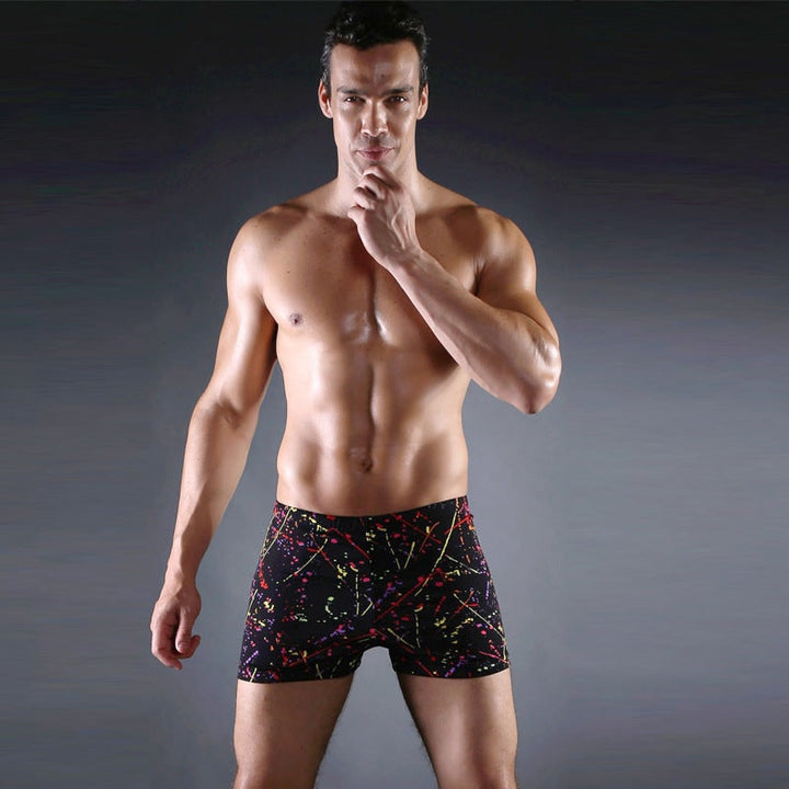 Dettaglio stampa grafica astratta su pantaloncini da bagno uomo. Colori vivaci, design moderno per la moda mare.