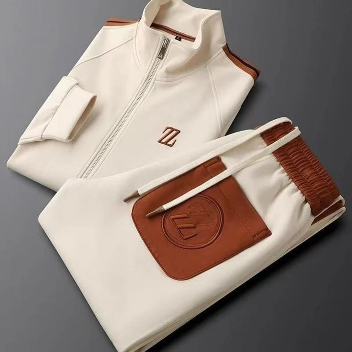 Tuta sportiva uomo elegante con giacca zip e pantaloni, ideale per athleisure e tempo libero.