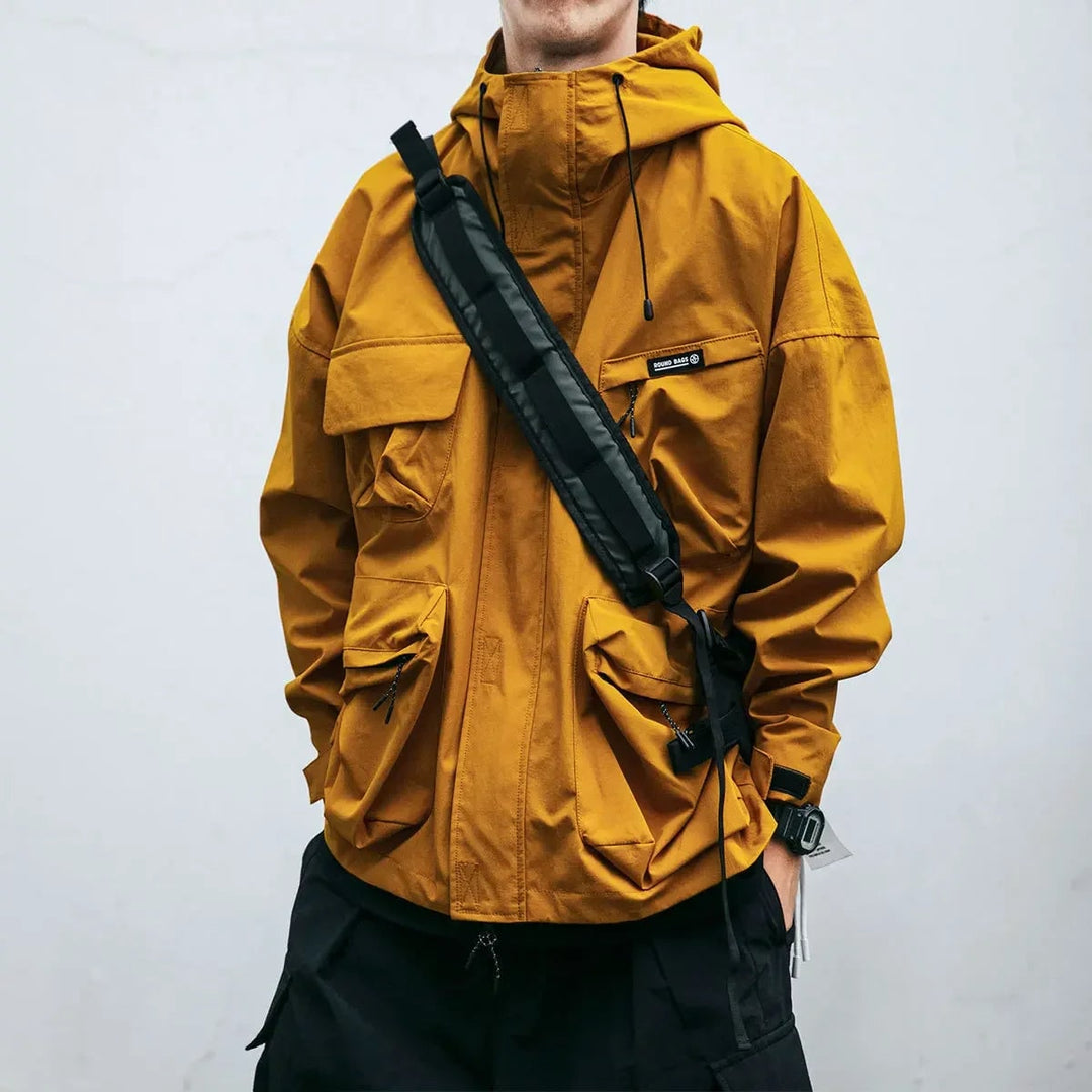 Giacca a vento utilità da uomo con cappuccio e tasche cargo, ideale per outdoor casual e lavoro in primavera/autunno.