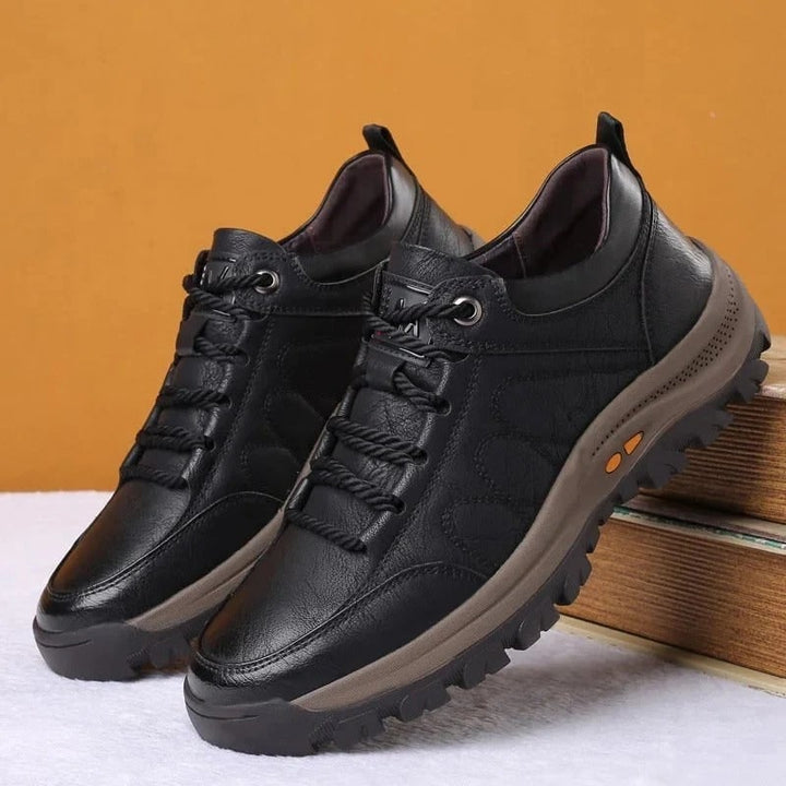 Primo piano su suola carrarmato di scarpe da passeggio uomo. Offre trazione affidabile e stabilità per trekking leggero.