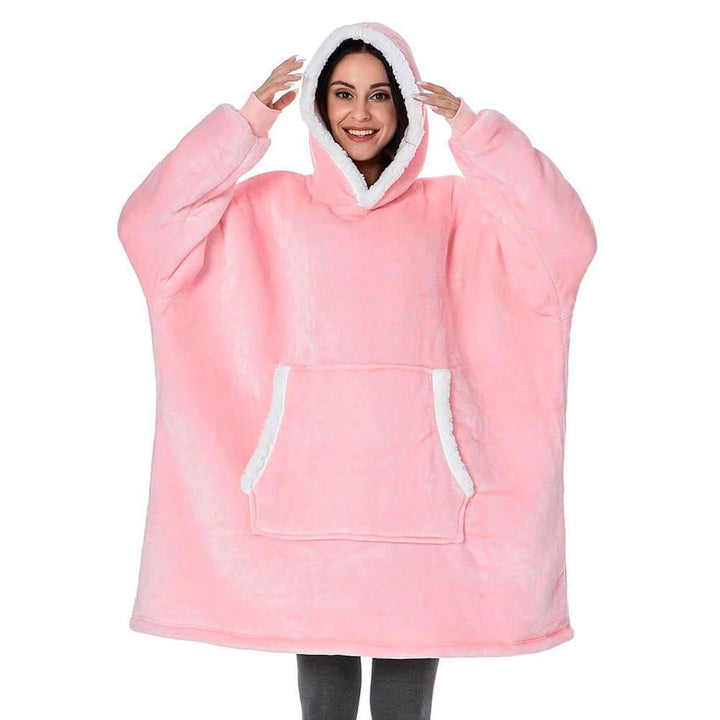 Uomo sul divano con felpa coperta oversize, simbolo di comfort, relax e calore in casa.