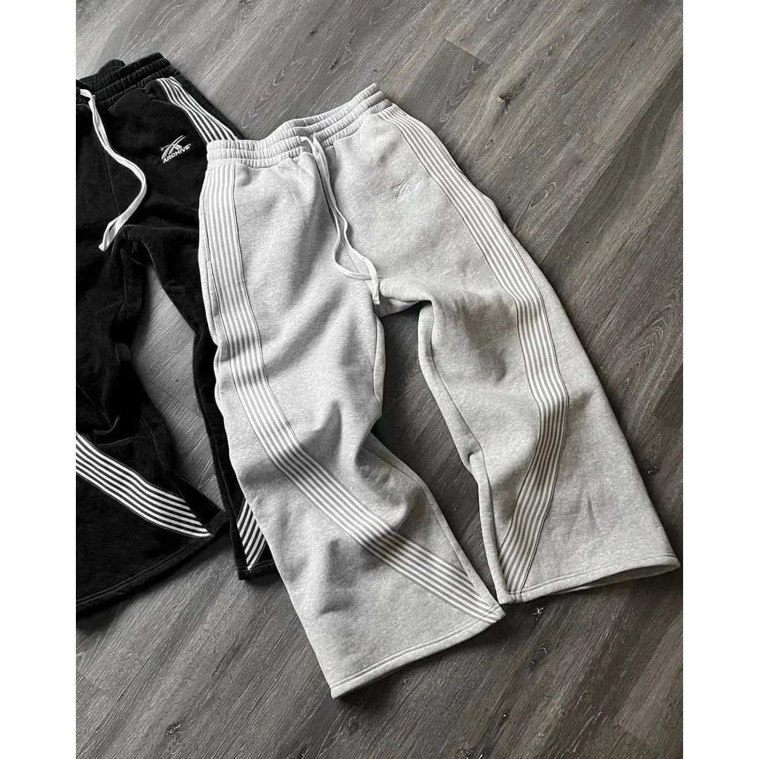 Pantaloni tuta uomo stile retrò, con strisce laterali e gamba larga, ideali per comfort casual quotidiano.