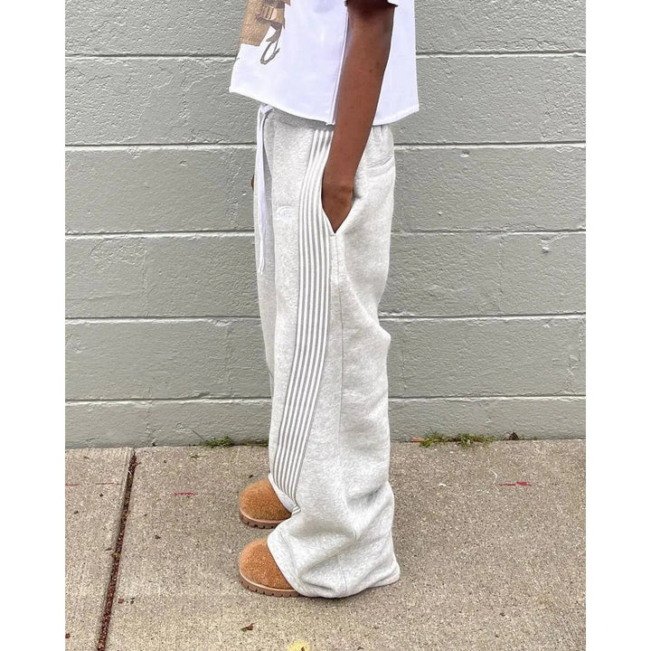 Pantaloni tuta uomo relax, taglio gamba larga, strisce laterali decorative e tasche funzionali.