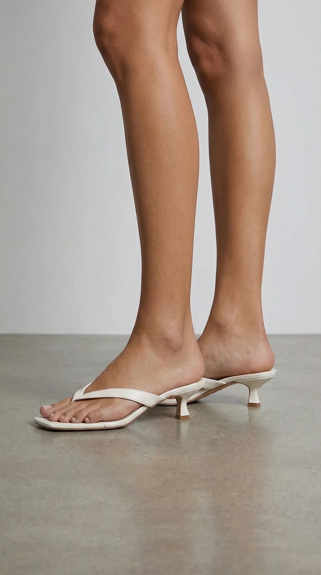 Sandali donna di tendenza, infradito con tacco gattino e fasce sottili per outfit estivi chic.