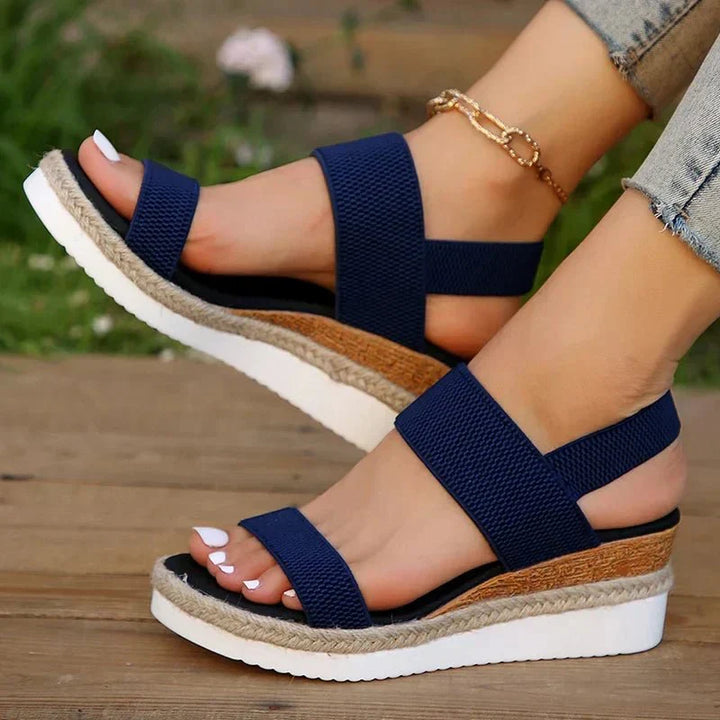 Primo piano sandali donna con zeppa e cinturino elastico, focus sul comfort e stile estivo.