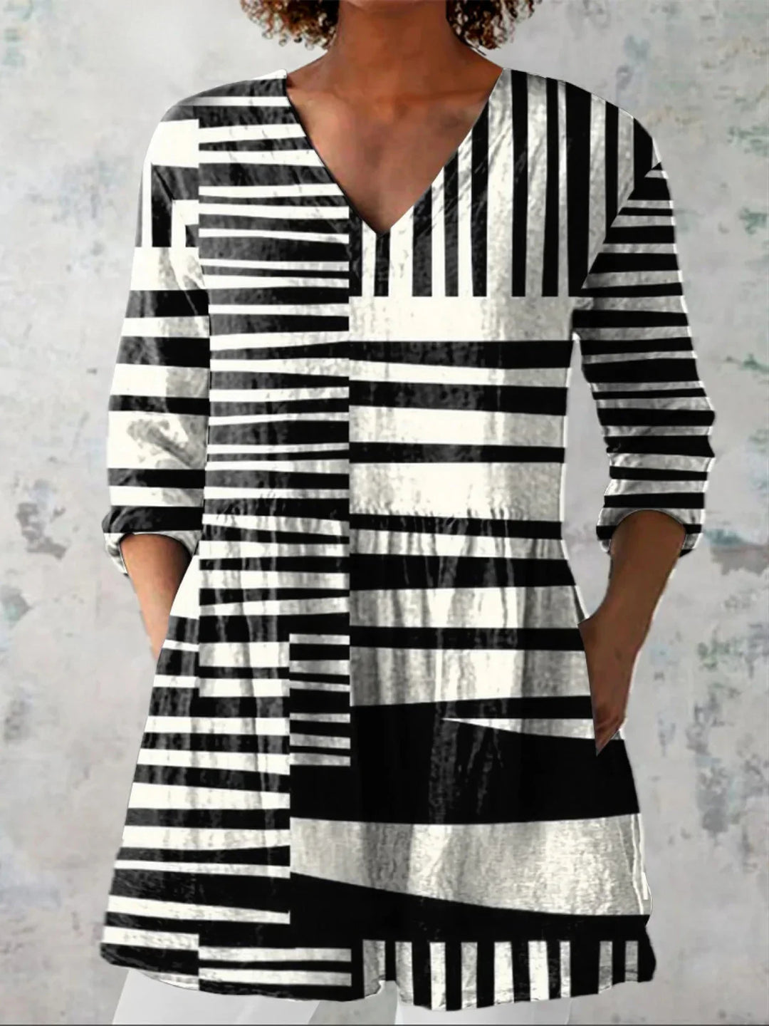 Camicetta da donna a righe con scollo a V, maniche tre quarti e tasche, elegante e versatile per look casual o chic.