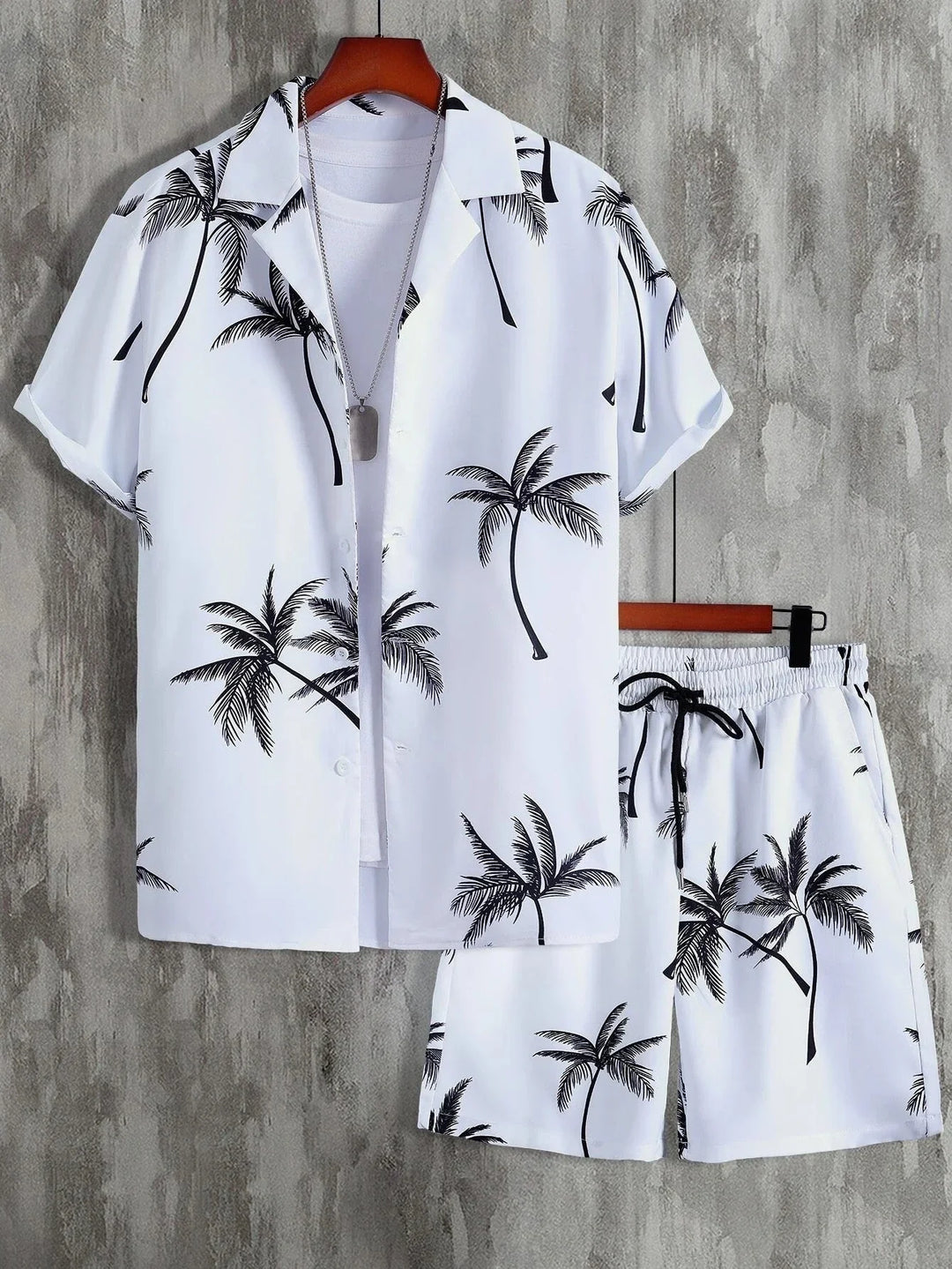 Uomo indossa completo estivo casual con stampa palma: camicia e pantaloncini per un look vacanza rilassato in spiaggia.