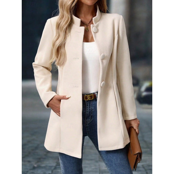 Donna indossa cappotto elegante nero con collo alto, mostrando la linea sfiancata. Ideale per ogni occasione.